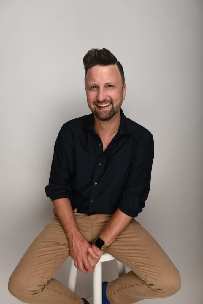 a man sitting on a stool with his legs crossed