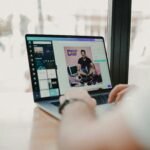 person using macbook pro on brown wooden table